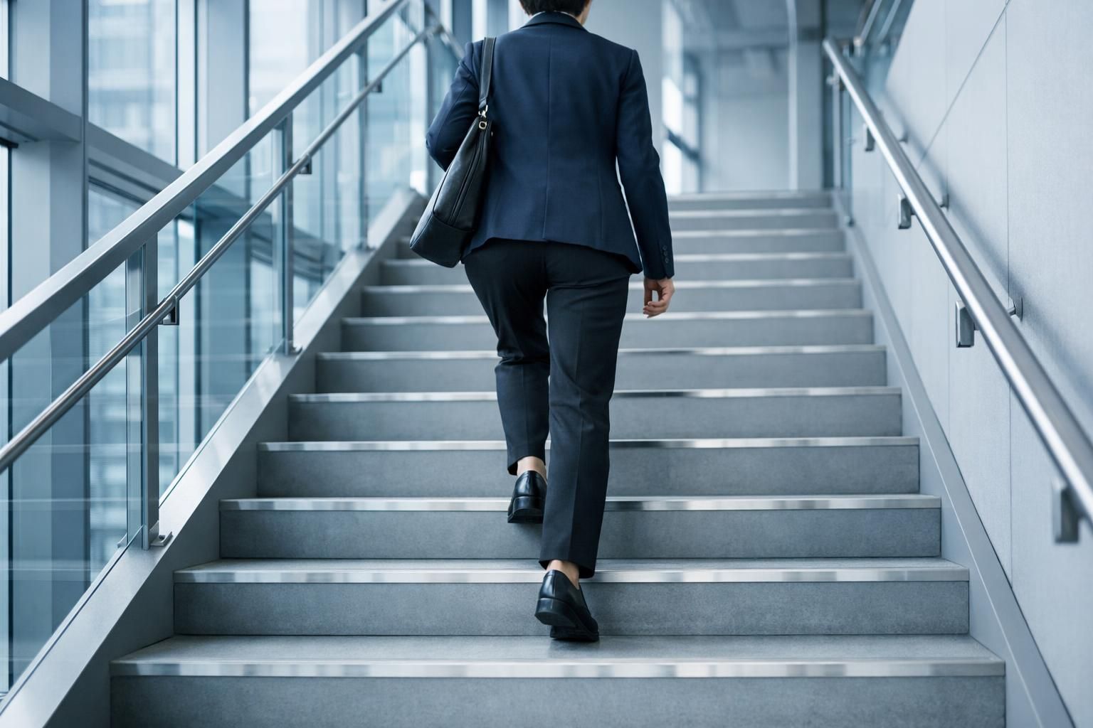 Personne gravissant un escalier de bureau, image des étapes successives de la contestation