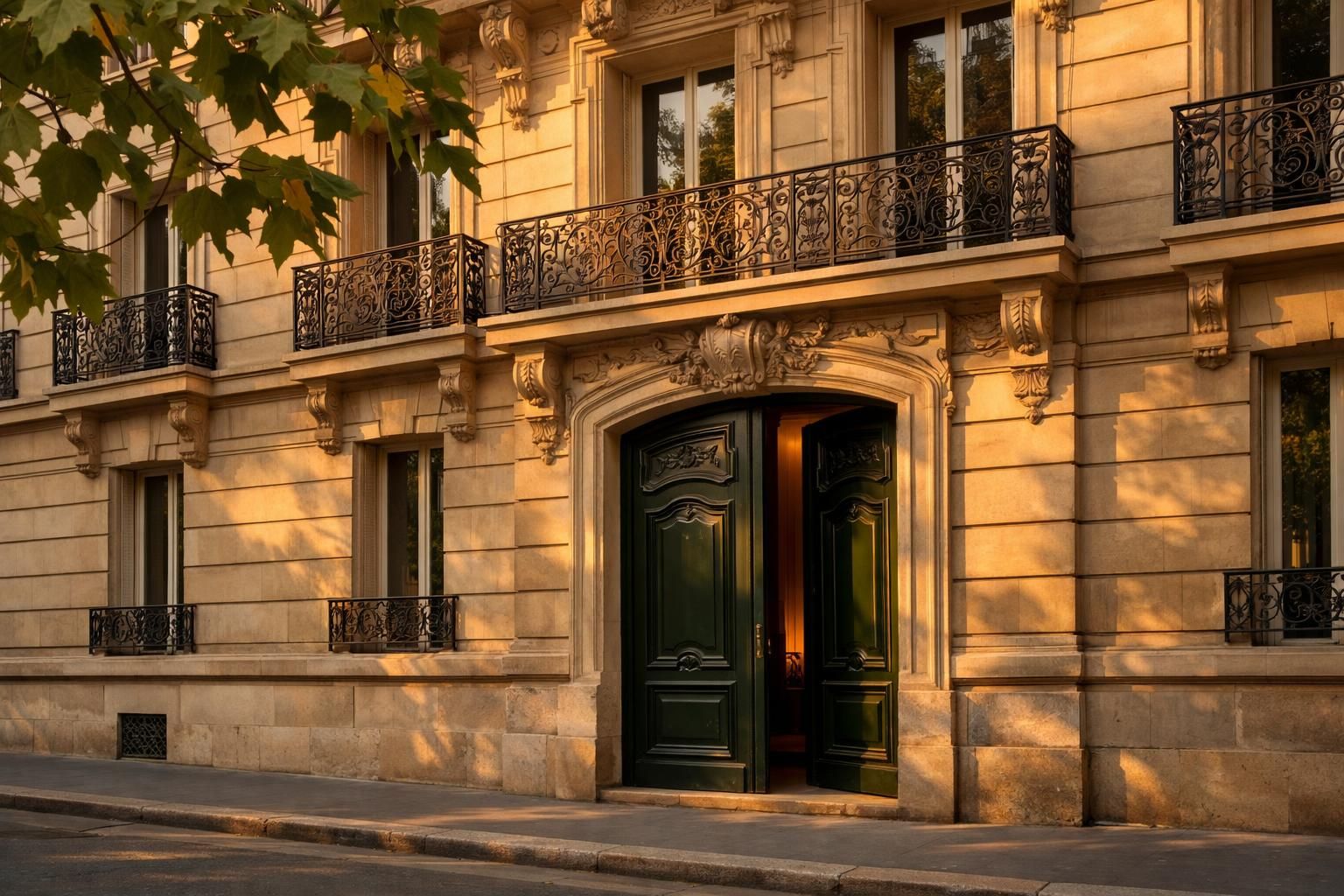 Façade d'immeuble haussmannien et porte cochère verte au soleil couchant